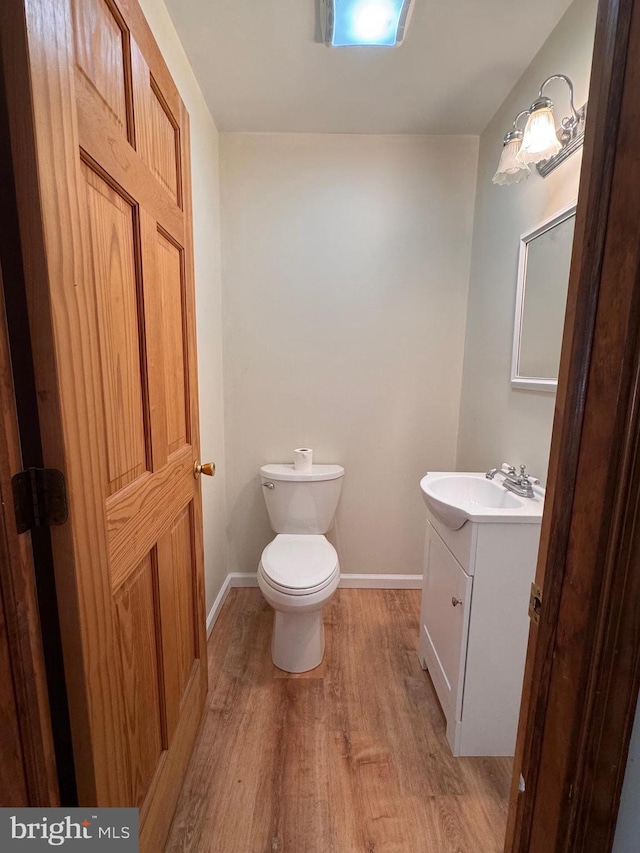 bathroom featuring hardwood / wood-style flooring, vanity, and toilet