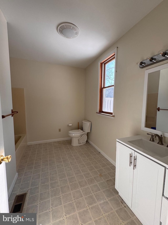 bathroom with vanity, a bathtub, and toilet