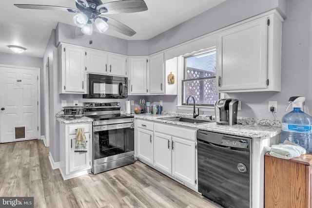 kitchen featuring sink, light wood-type flooring, white cabinets, light stone countertops, and black appliances