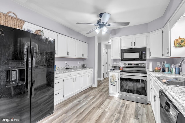 kitchen featuring black appliances, light stone countertops, white cabinetry, sink, and light hardwood / wood-style flooring