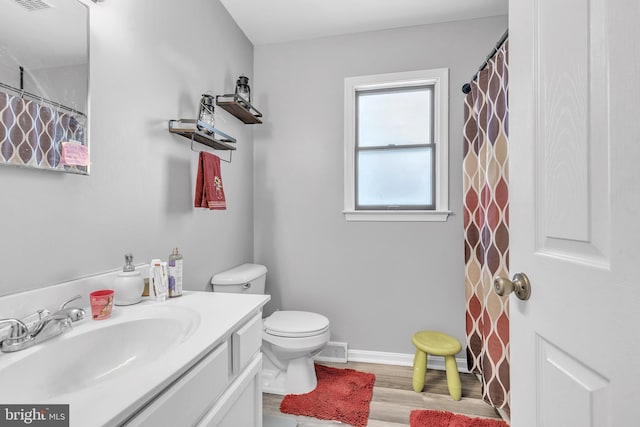 bathroom with hardwood / wood-style floors, toilet, and vanity