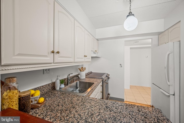 kitchen featuring sink, white cabinetry, stainless steel range oven, and white fridge