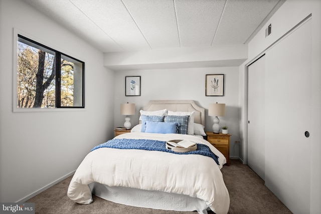 carpeted bedroom featuring a closet and a textured ceiling