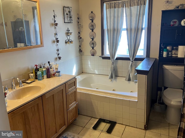 bathroom with vanity, tiled tub, tile patterned floors, and toilet