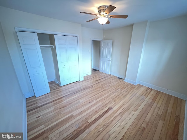 unfurnished bedroom featuring ceiling fan, light hardwood / wood-style flooring, and a closet