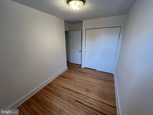 unfurnished bedroom featuring a closet and light hardwood / wood-style floors