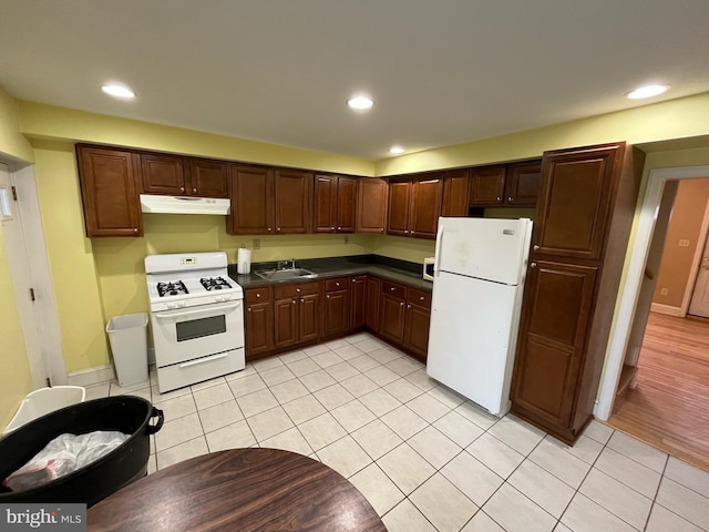 kitchen featuring sink, white appliances, and light tile patterned floors