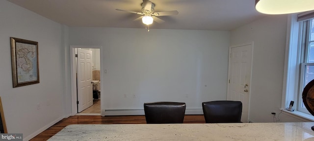 home office featuring a baseboard heating unit, dark hardwood / wood-style floors, and ceiling fan