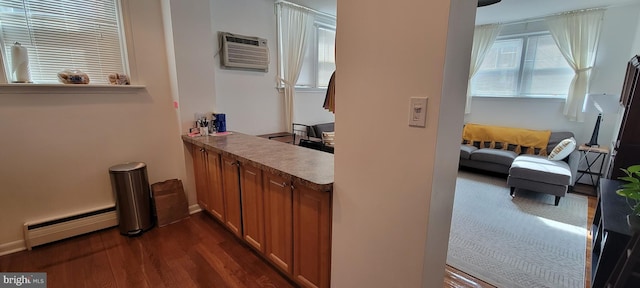 hallway featuring a baseboard radiator, dark hardwood / wood-style flooring, and a wall unit AC