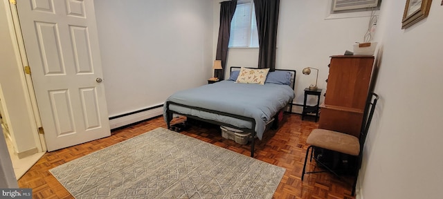 bedroom with a wall mounted AC, dark parquet floors, and baseboard heating