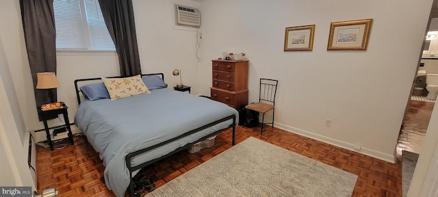 bedroom featuring a baseboard heating unit, dark parquet floors, and an AC wall unit