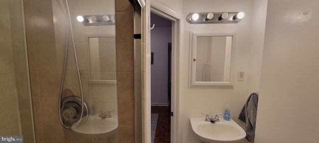 bathroom with sink and a tile shower