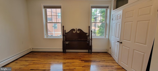 interior space with hardwood / wood-style flooring, a baseboard radiator, and a wealth of natural light