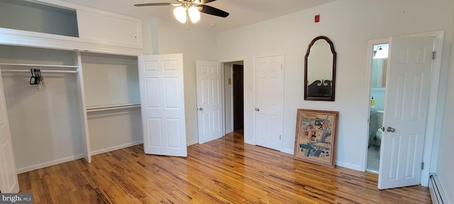 unfurnished bedroom with hardwood / wood-style flooring, a baseboard radiator, ceiling fan, and a closet