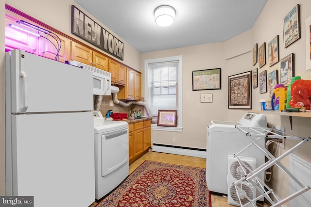 laundry room with a baseboard heating unit and washing machine and clothes dryer