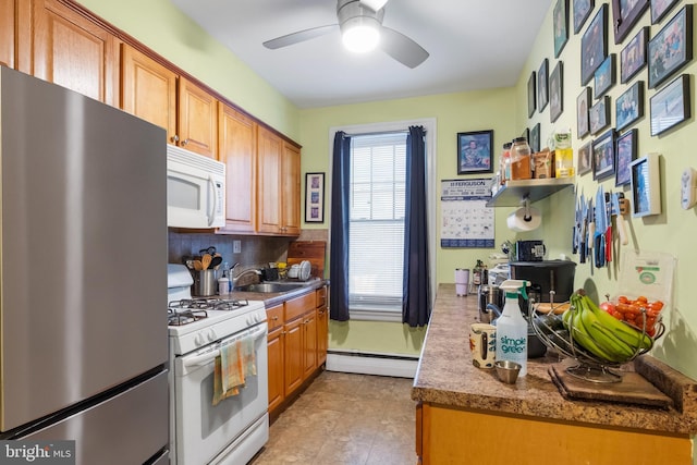 kitchen featuring sink, white appliances, ceiling fan, baseboard heating, and backsplash