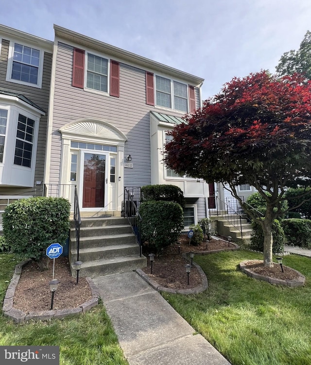 townhome / multi-family property with a front lawn