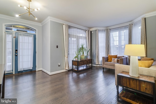 entryway with crown molding, dark hardwood / wood-style flooring, and an inviting chandelier