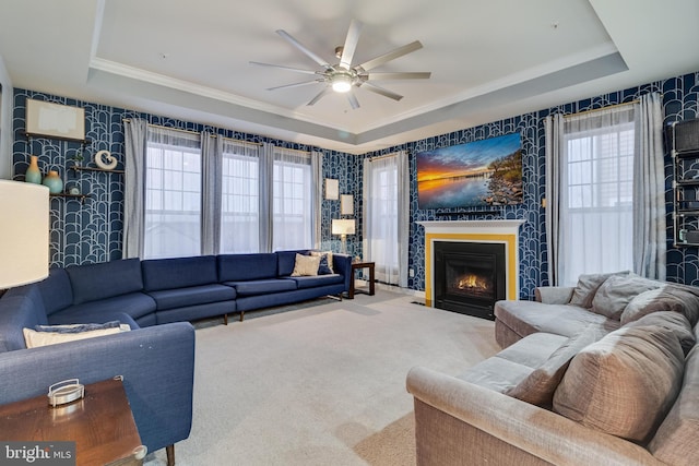 living room featuring a tray ceiling, a wealth of natural light, and carpet flooring