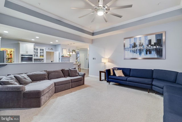 carpeted living room with ornamental molding and ceiling fan