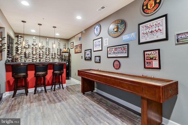 recreation room featuring wood-type flooring and bar area