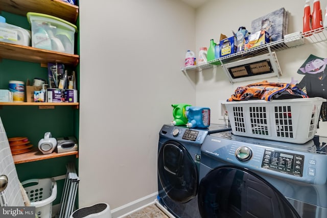 clothes washing area featuring washer and clothes dryer and light tile patterned floors