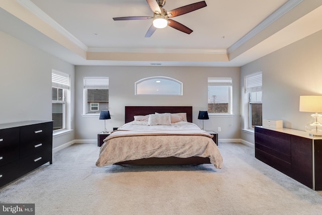 carpeted bedroom with crown molding, a raised ceiling, and ceiling fan