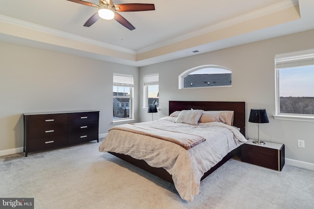 bedroom featuring crown molding, light colored carpet, a raised ceiling, and ceiling fan