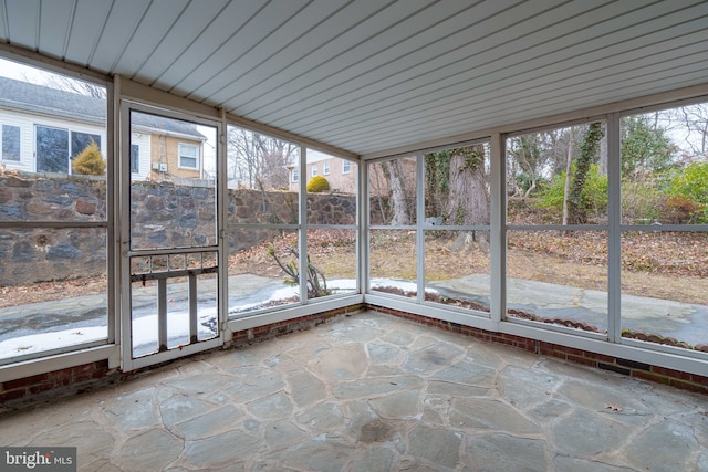 unfurnished sunroom featuring vaulted ceiling