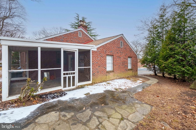 snow covered house with a sunroom