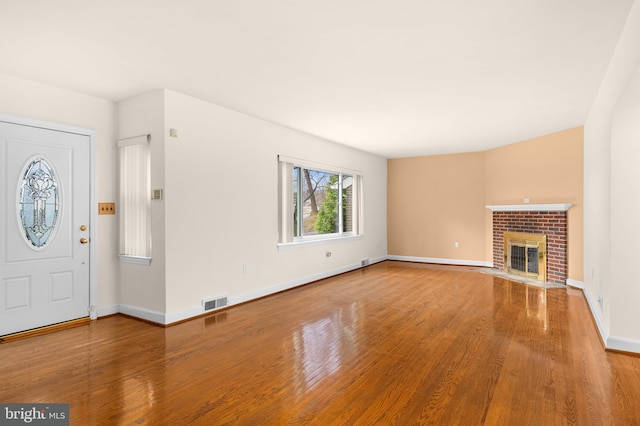 unfurnished living room with a fireplace and wood-type flooring