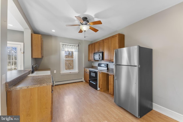 kitchen with sink, range with electric stovetop, stainless steel refrigerator, baseboard heating, and light hardwood / wood-style floors