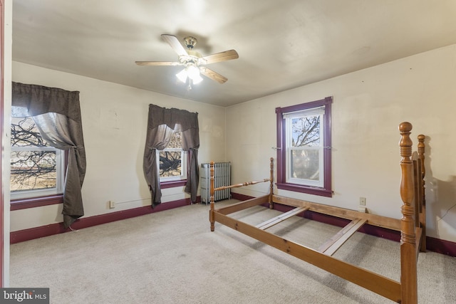 unfurnished bedroom featuring ceiling fan, radiator heating unit, and carpet floors