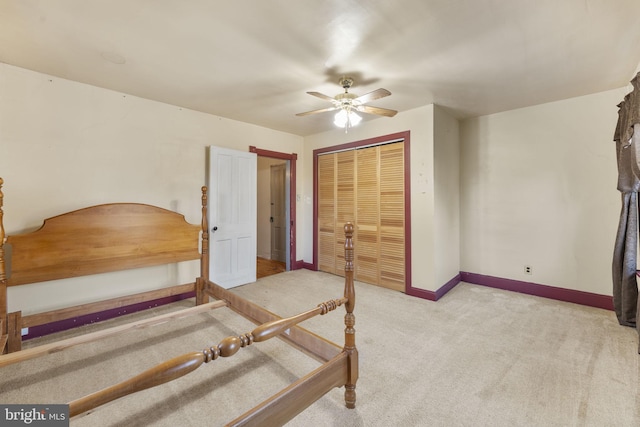 bedroom featuring ceiling fan, light colored carpet, and a closet