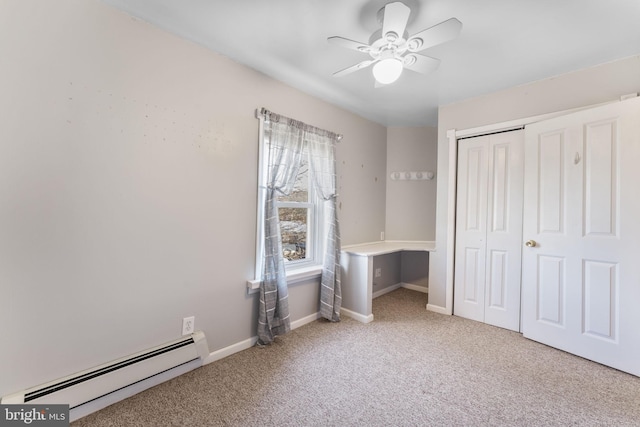 unfurnished bedroom featuring a baseboard heating unit, a closet, ceiling fan, and carpet