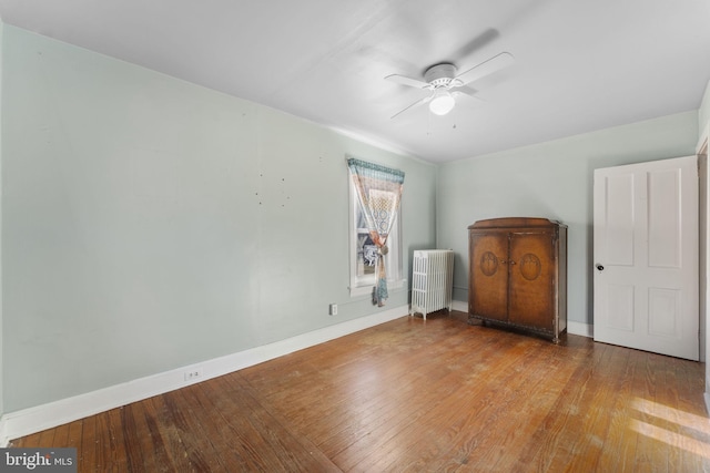 unfurnished bedroom featuring ceiling fan, radiator heating unit, and light hardwood / wood-style floors