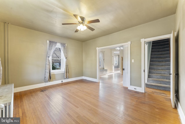 unfurnished living room featuring ceiling fan and light hardwood / wood-style flooring