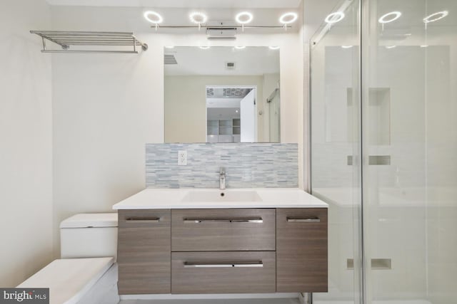 bathroom with a shower with door, tasteful backsplash, and vanity