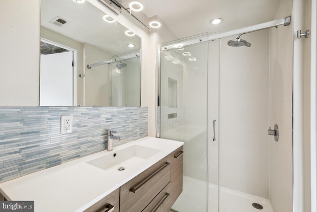 bathroom with an enclosed shower, vanity, and tasteful backsplash