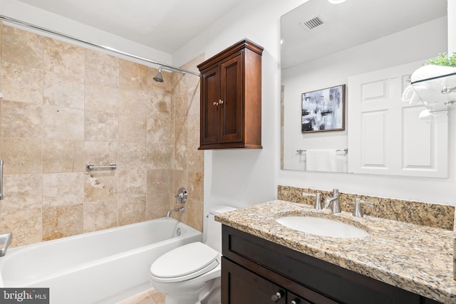 full bathroom featuring vanity, tiled shower / bath, and toilet