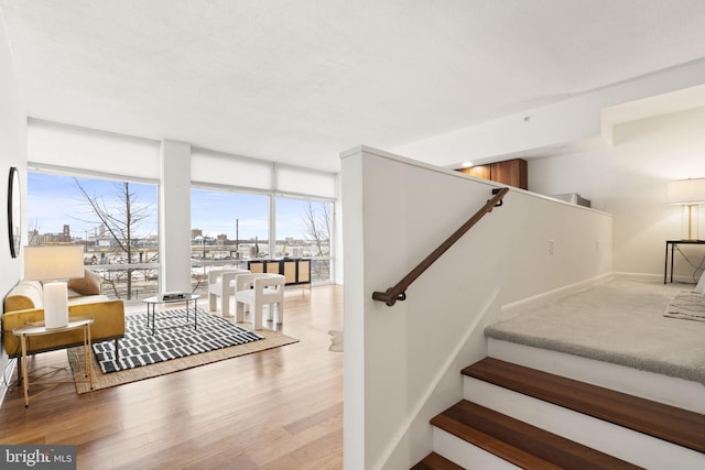 stairs featuring wood-type flooring and floor to ceiling windows