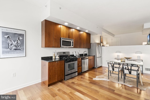 kitchen featuring stainless steel appliances, sink, and light hardwood / wood-style floors