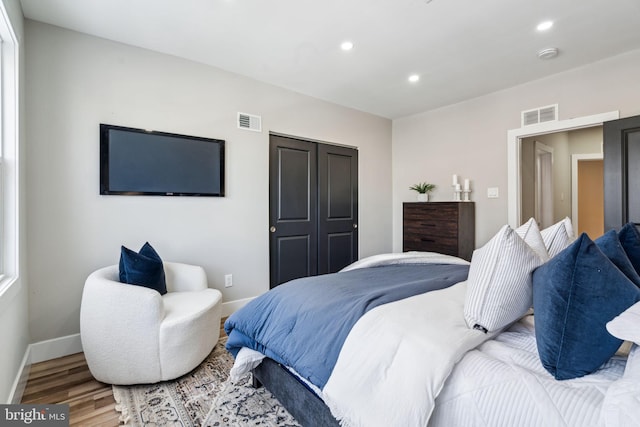 bedroom with a closet and hardwood / wood-style flooring