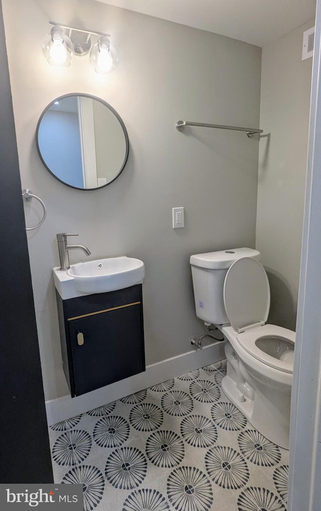 bathroom featuring toilet, tile patterned flooring, and vanity