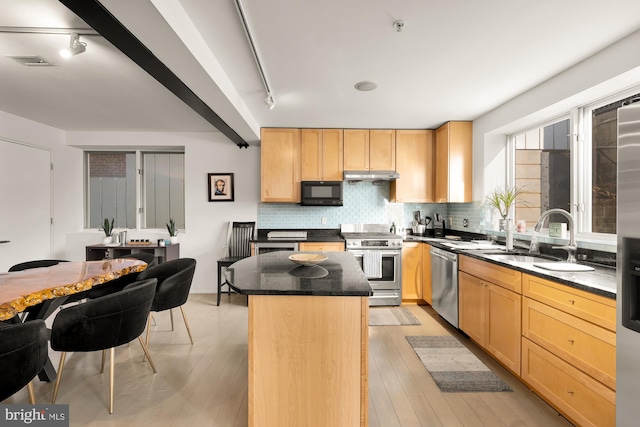 kitchen with appliances with stainless steel finishes, a center island, light brown cabinets, sink, and rail lighting