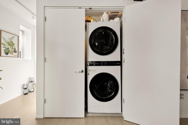 clothes washing area featuring stacked washing maching and dryer