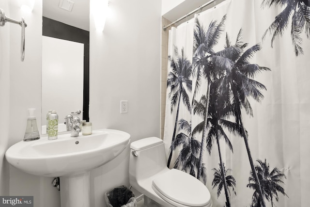 bathroom featuring toilet and a shower with curtain