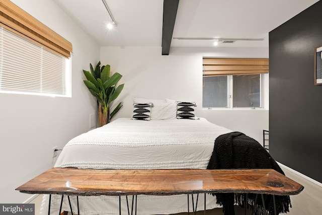 bedroom with rail lighting and beam ceiling