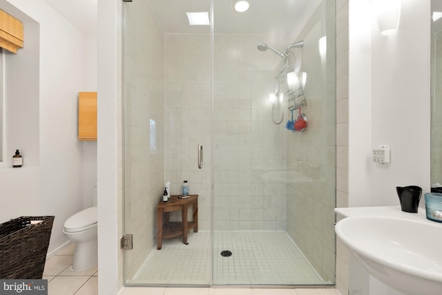 bathroom with sink, tile patterned floors, walk in shower, and toilet