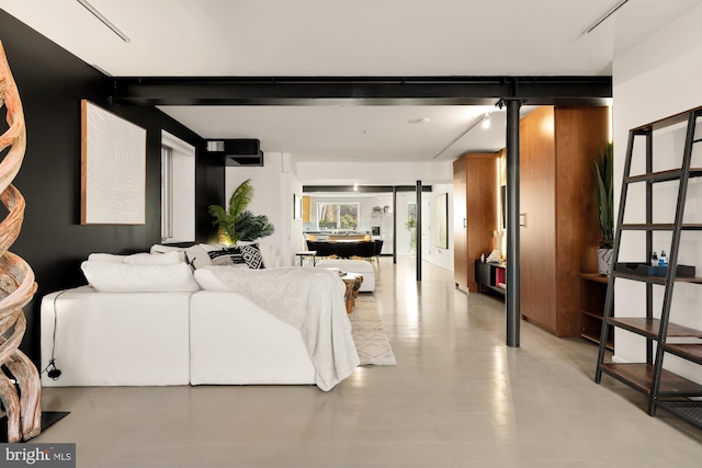 living room featuring a barn door and beam ceiling